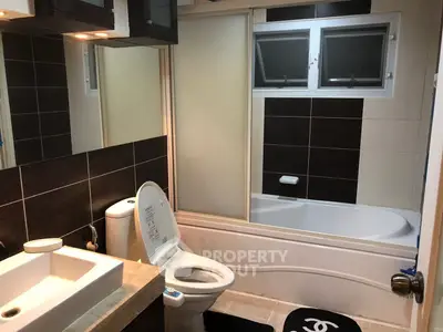 Modern bathroom with bathtub and sleek design, featuring stylish tiles and contemporary fixtures.