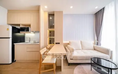 Modern open-layout living room with cozy sofa and stylish kitchen area, perfect for urban living.
