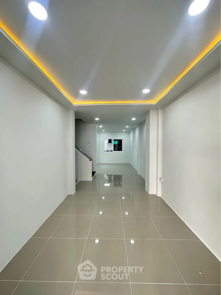Spacious modern interior with recessed lighting and glossy tiled flooring.