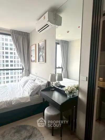 Modern bedroom with city view, featuring stylish decor and natural light, perfect for urban living.