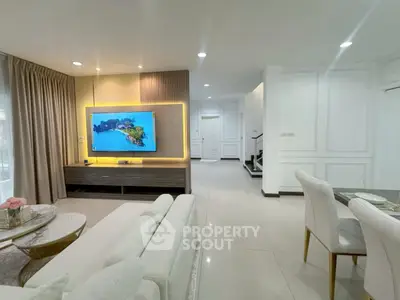 Modern living room with elegant decor and open layout, featuring a stylish TV unit and dining area.