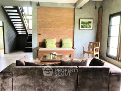 Charming living room with rustic brick wall and cozy seating area, perfect for relaxation and entertaining.
