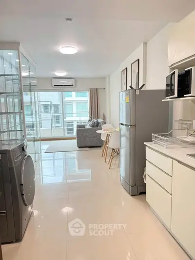 Modern open-plan kitchen and living area with sleek appliances and bright natural light.