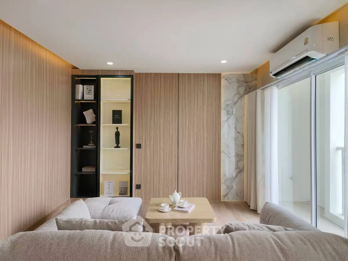 Modern living room with elegant decor and natural light, featuring a cozy sofa and stylish shelving.