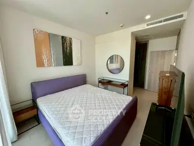 Modern bedroom with stylish decor and purple bed frame in a cozy apartment.