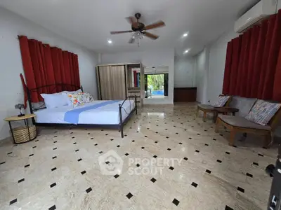 Spacious bedroom with elegant flooring and modern furnishings, featuring a ceiling fan and air conditioning.