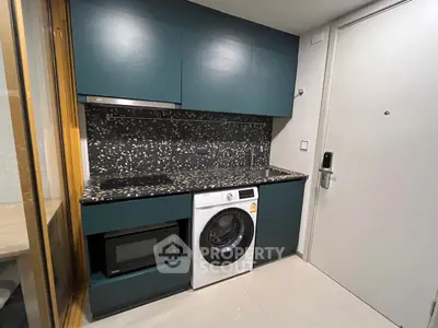 Modern compact kitchen with washing machine and microwave in sleek apartment