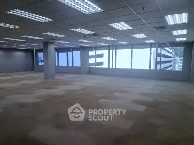 Spacious office space with large windows and ample natural light in a modern building.