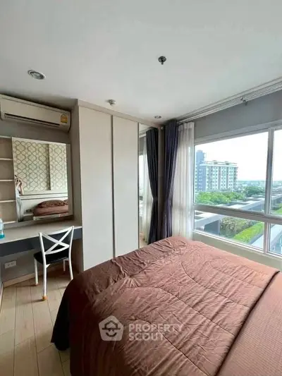 Cozy bedroom with large windows offering a stunning city view, featuring a comfortable bed and stylish decor.