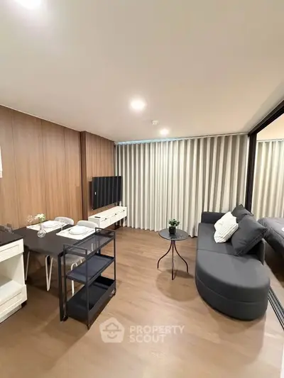 Modern living room with sleek furniture and wooden flooring, perfect for cozy gatherings.