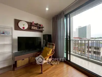 Charming living room with balcony view, featuring modern decor and natural light, perfect for relaxation.