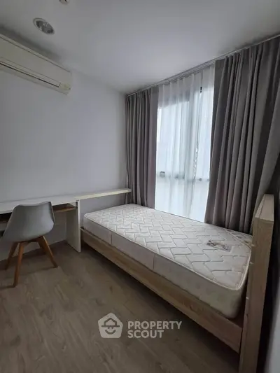 Modern minimalist bedroom with single bed, study desk, and large window with curtains.