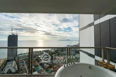 Stunning ocean view from high-rise balcony with luxurious bathtub.