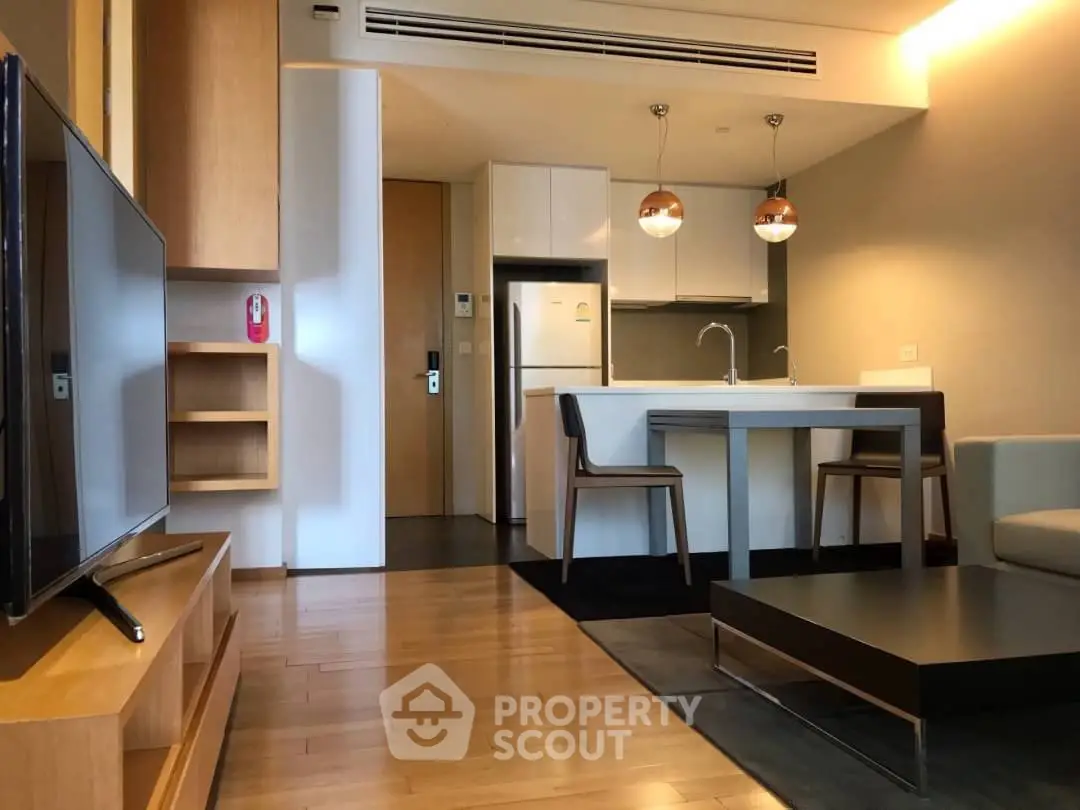 Modern open-plan living room with sleek kitchen and stylish furniture in a contemporary apartment.