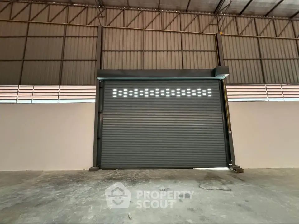 Spacious industrial warehouse with large roller door and high ceilings.