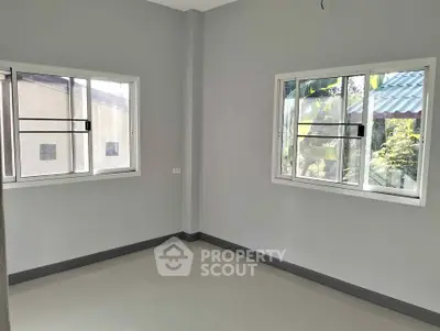 Bright empty room with large windows and neutral walls, perfect for customization.
