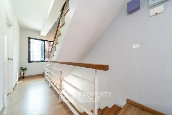 Bright modern staircase with wooden railing and natural light