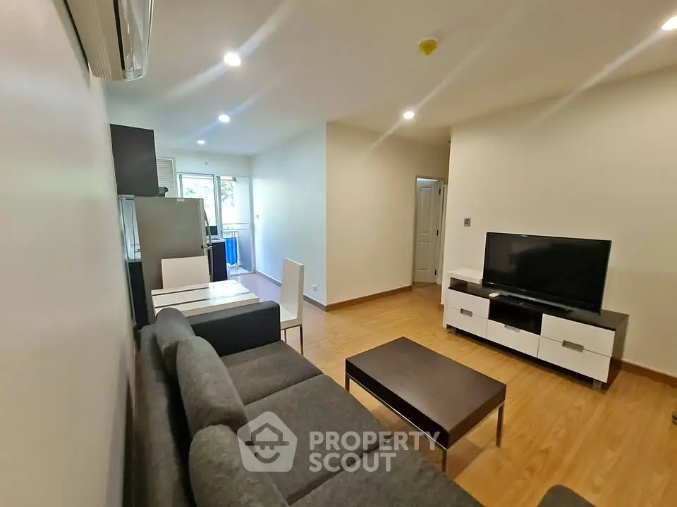 Modern living room with sleek furniture and wooden flooring in a cozy apartment.