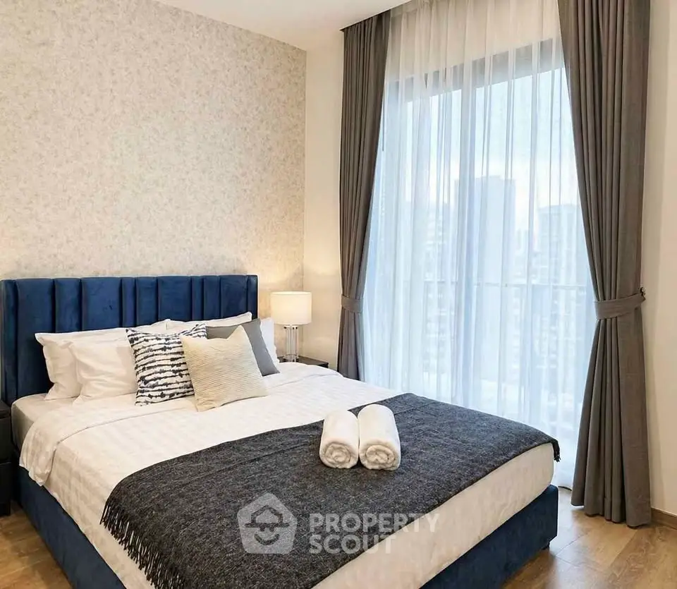 Luxurious bedroom with elegant decor and city view, featuring a plush bed and floor-to-ceiling windows.