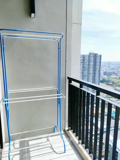High-rise balcony with city view and drying rack, perfect for urban living.