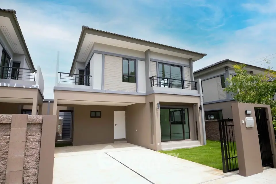 Modern two-story house with driveway and gated entrance in a suburban neighborhood.