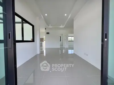 Spacious modern living room with glossy tiled floors and large windows.
