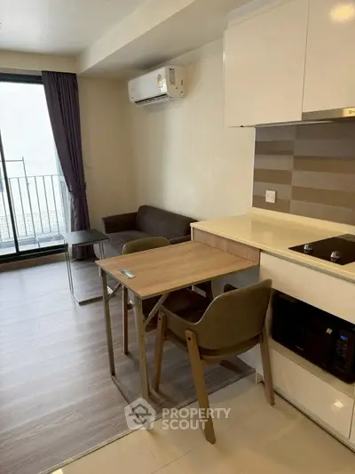 Modern compact living room with kitchen and balcony access