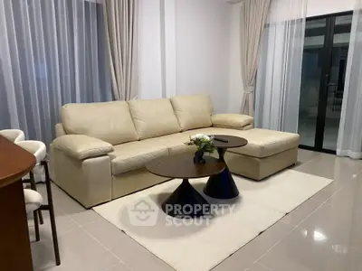 Elegant living room with plush beige sofa and modern coffee tables, perfect for relaxation and entertaining.
