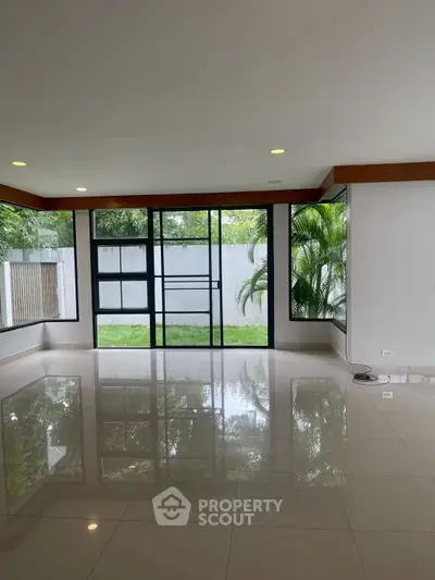 Spacious modern living room with large windows and garden view, perfect for natural light lovers.