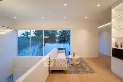 Modern living room with large windows and elegant lighting in a stylish home.