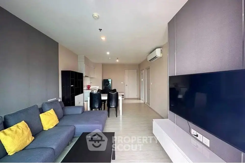 Modern living room with sleek furniture and wall-mounted TV, perfect for relaxation.