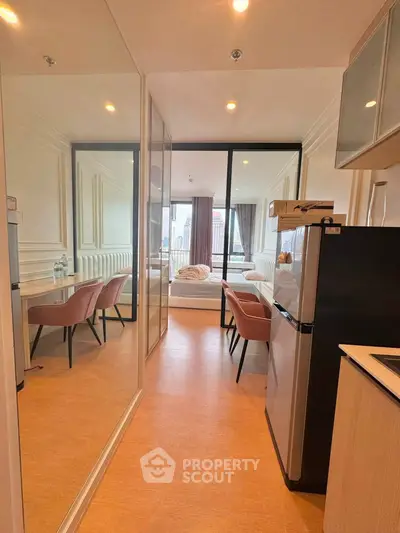 Modern studio apartment with open layout, featuring a cozy bedroom and compact kitchen area.