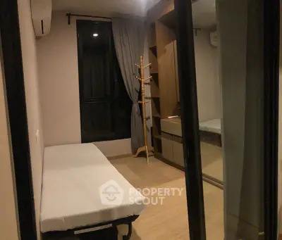 Cozy bedroom with modern minimalist design, featuring a comfortable bed, sleek wooden wardrobe, and elegant drapery, ideal for urban living.