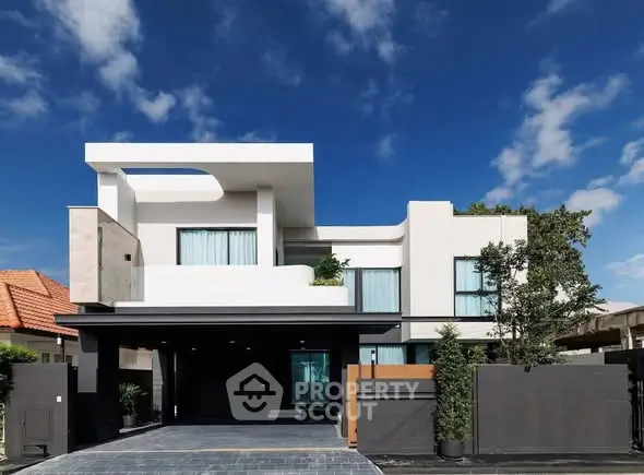 Modern luxury house exterior with sleek design and spacious layout under a clear blue sky.
