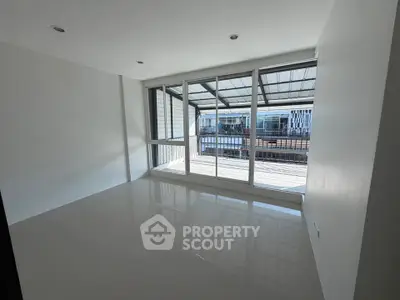 Spacious modern room with large windows and balcony access, perfect for natural light lovers.