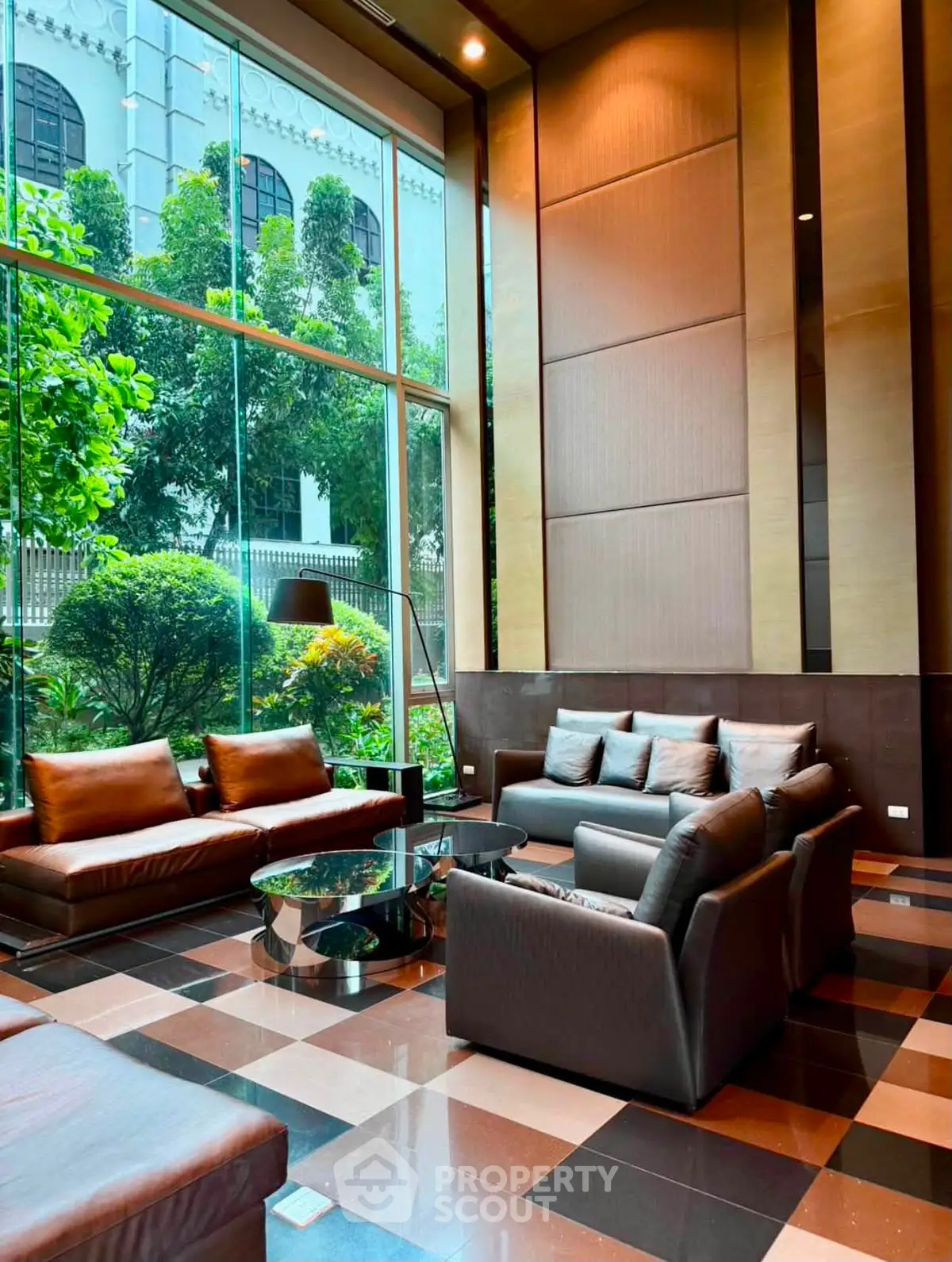 Luxurious lobby with modern seating and large windows overlooking lush greenery.
