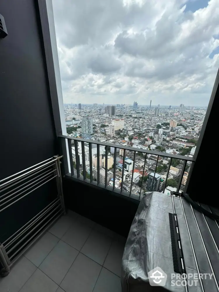 Stunning city view from high-rise balcony with modern railing and tiled floor.