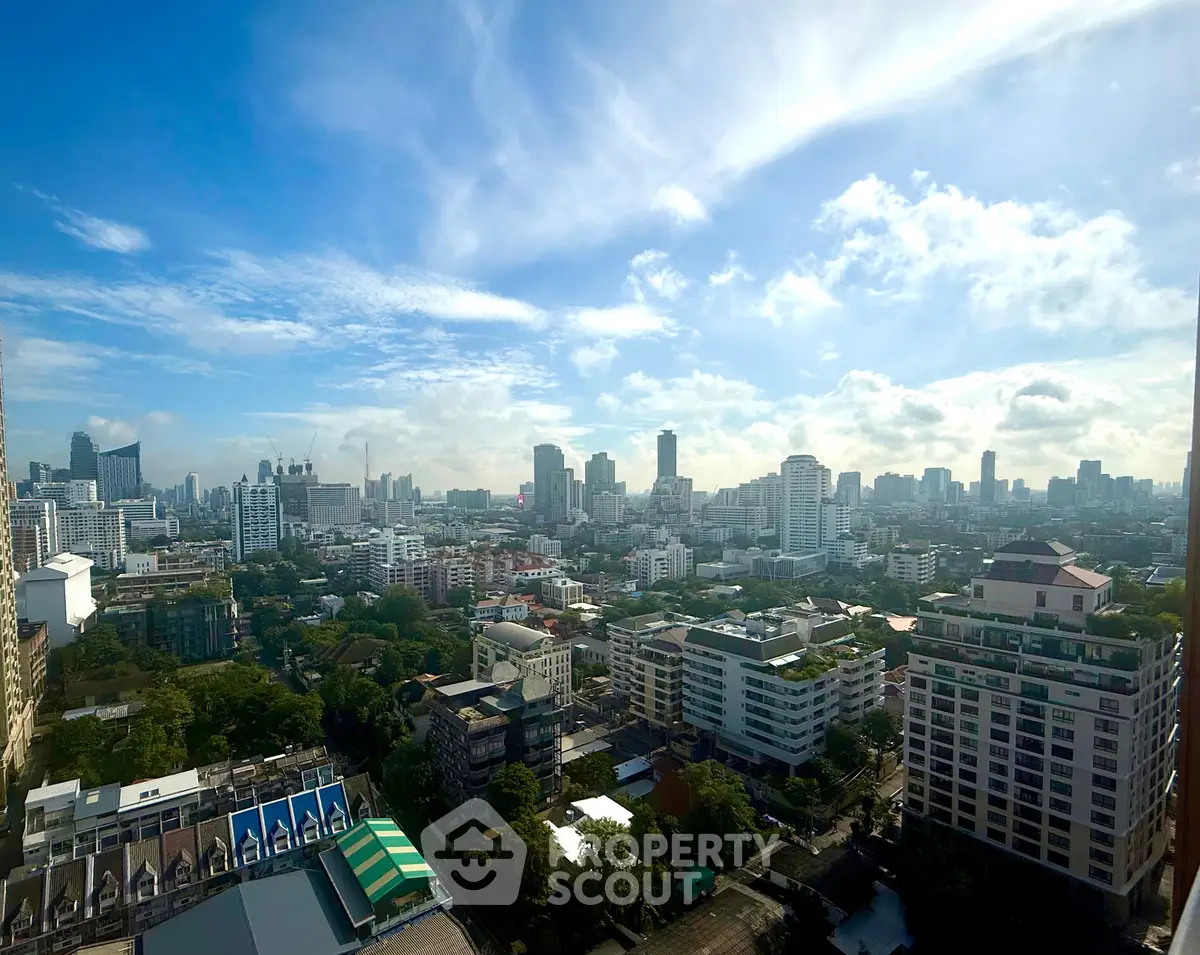 Stunning cityscape view from a high-rise building showcasing urban skyline and lush greenery.