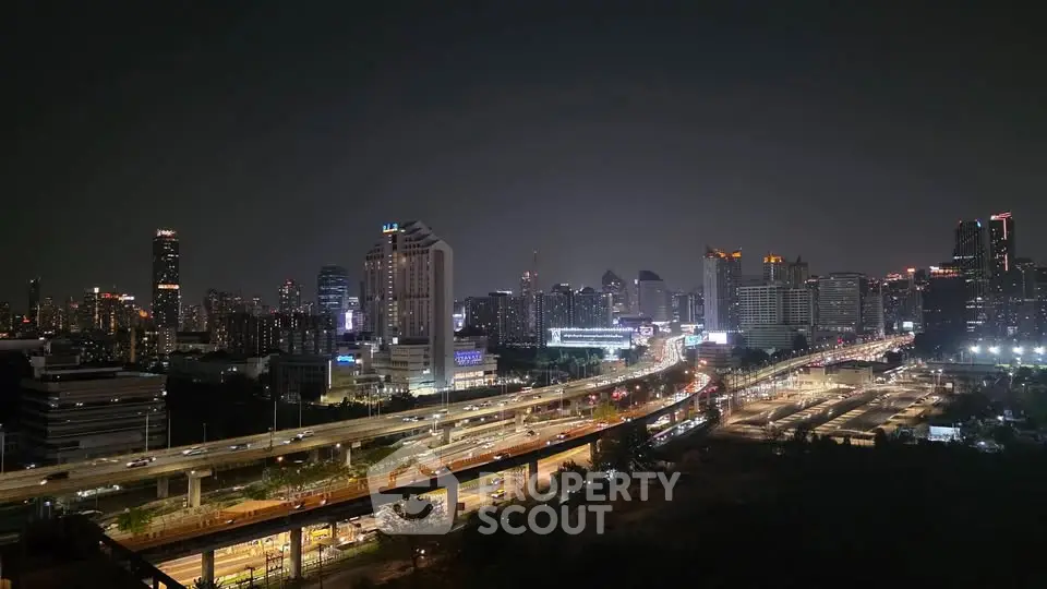 Stunning nighttime cityscape view with illuminated skyline and busy highways.