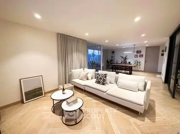 Spacious modern living room with elegant decor and open layout, featuring stylish furniture and ambient lighting.