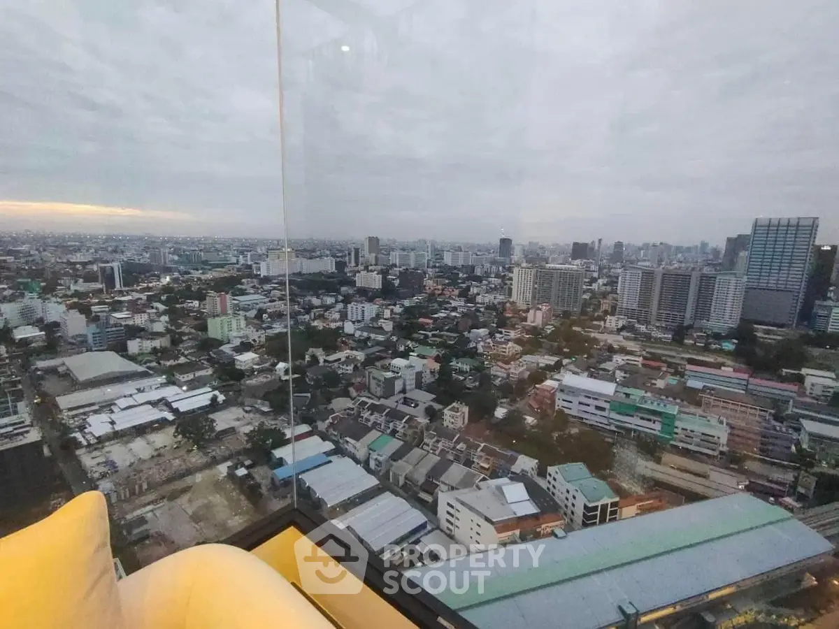 Stunning panoramic city view from high-rise apartment with floor-to-ceiling windows.