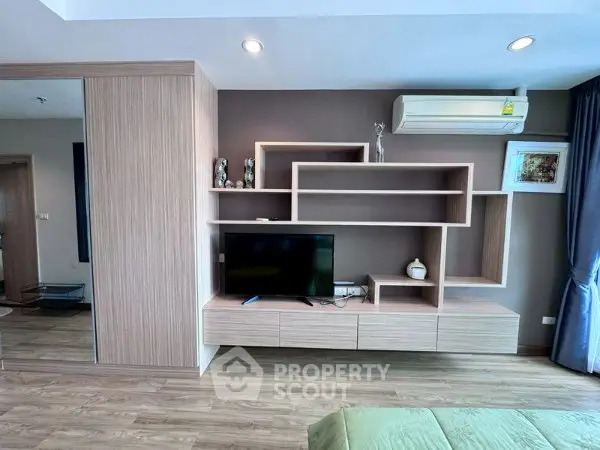Modern living room with stylish wooden shelving and air conditioning unit, perfect for contemporary living.