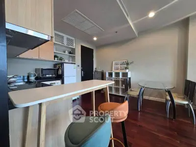 Modern kitchen with open layout and stylish dining area in a cozy apartment.