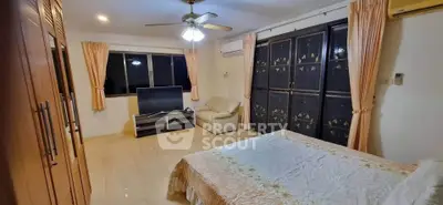 Spacious bedroom with elegant decor and large windows for natural light.