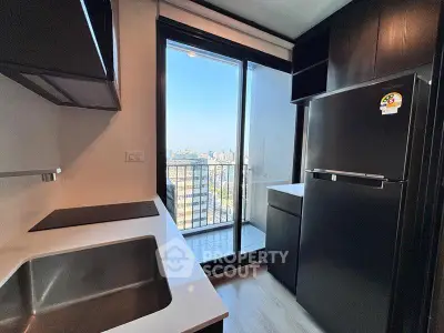 Modern kitchen with sleek appliances and balcony view in urban apartment
