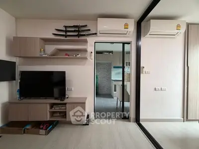 Modern living room with sleek design, featuring wall-mounted TV and dual air conditioning units.