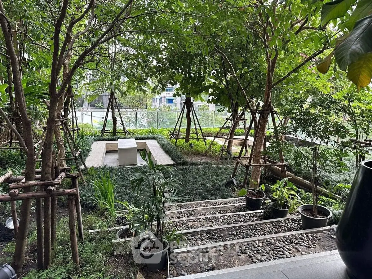 Lush garden with stone pathway and modern seating area, perfect for relaxation and outdoor enjoyment.