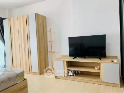 Modern bedroom with wooden furniture and flat-screen TV, perfect for cozy living.