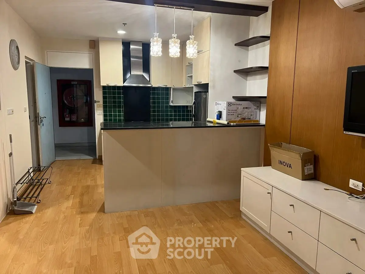 Modern kitchen with open layout and stylish lighting in a cozy apartment.