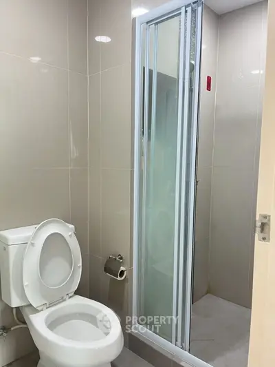 Modern bathroom with sleek shower and toilet in neutral tones
